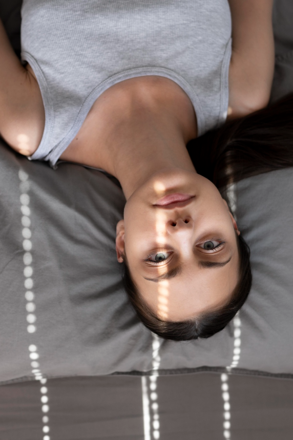 Woman lying on a bed suffering from substance use disorder