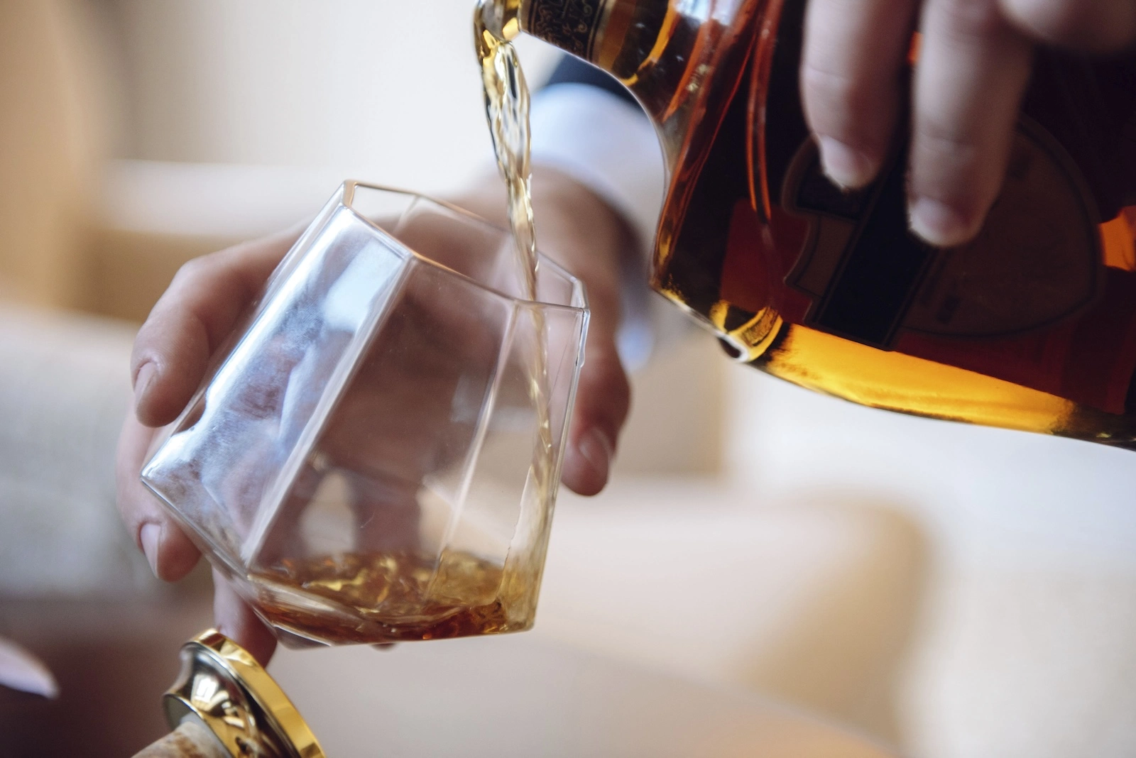 person pouring whiskey into a tumbler glass; can you drink while on accutane?