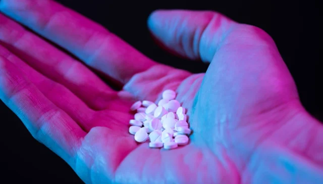 person holding a handful of white pills; can you overdose on ketamine