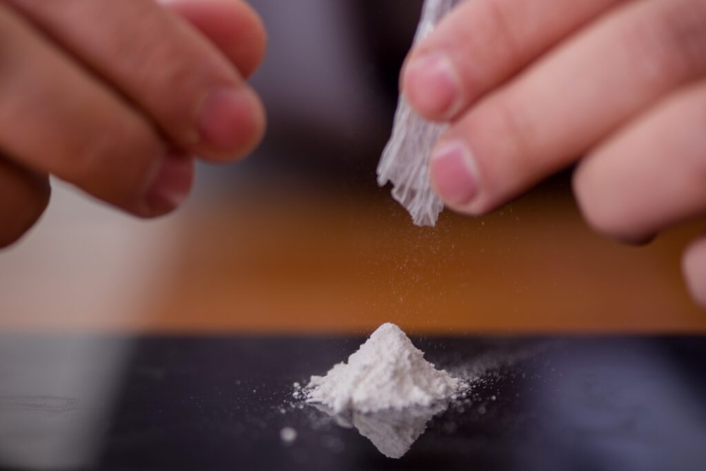 person emptying white powder onto a table