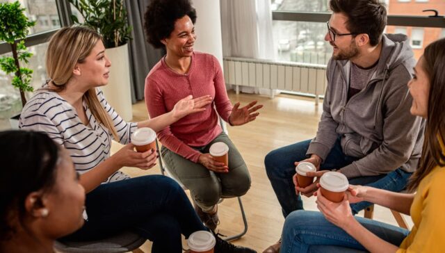 AA Promises: A group of people sitting in chairs in a circle