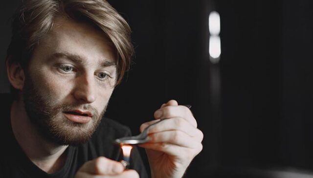 Dilated Pupils and Drugs: A man staring at a flame and a spoon.