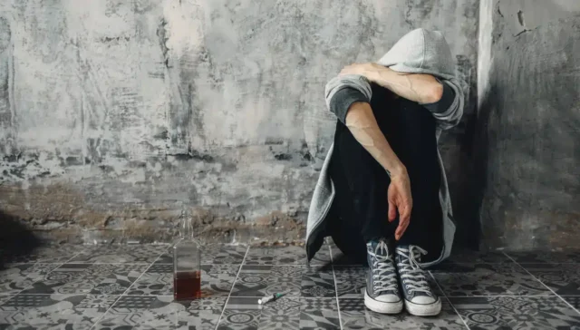 Gabapentin withdrawal effects. Depressed druggy sitting on the floor, withdrawal symptom