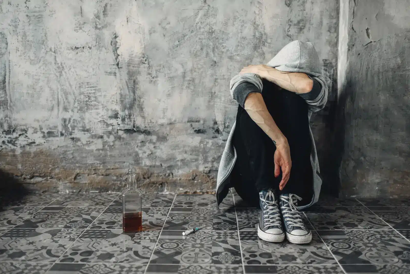 Gabapentin withdrawal effects. Depressed druggy sitting on the floor, withdrawal symptom