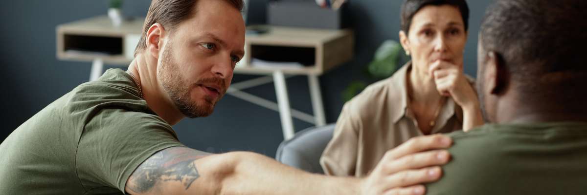 Therapist offering support to a person and veteran in trauma-informed treatment for PTSD and addiction recovery