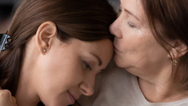 Concerned parent comforting their struggling adult child during a supportive conversation about addiction